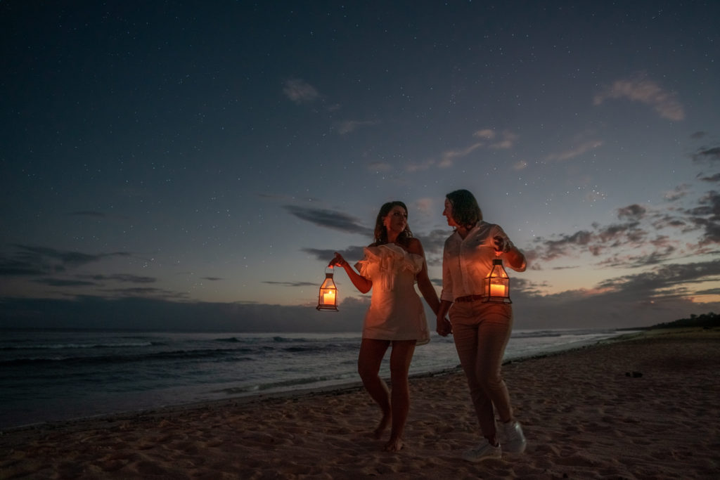 Couple taking a stroll down the beach during the blue hour, following their beach elopement