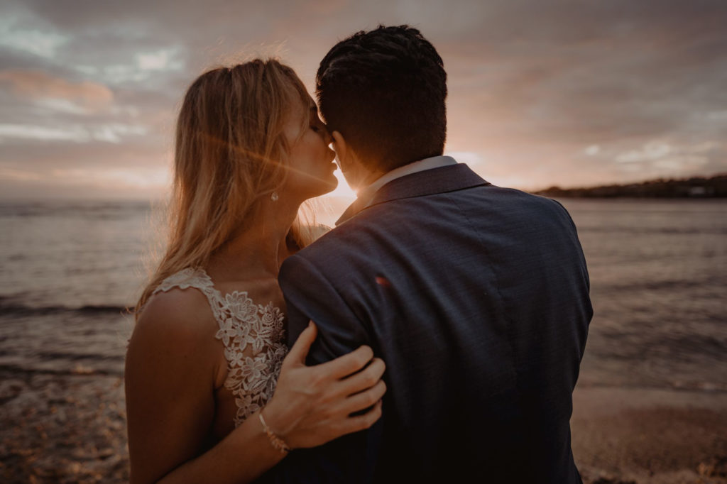 couple enjoying sunset over the ocean during their beach elopement