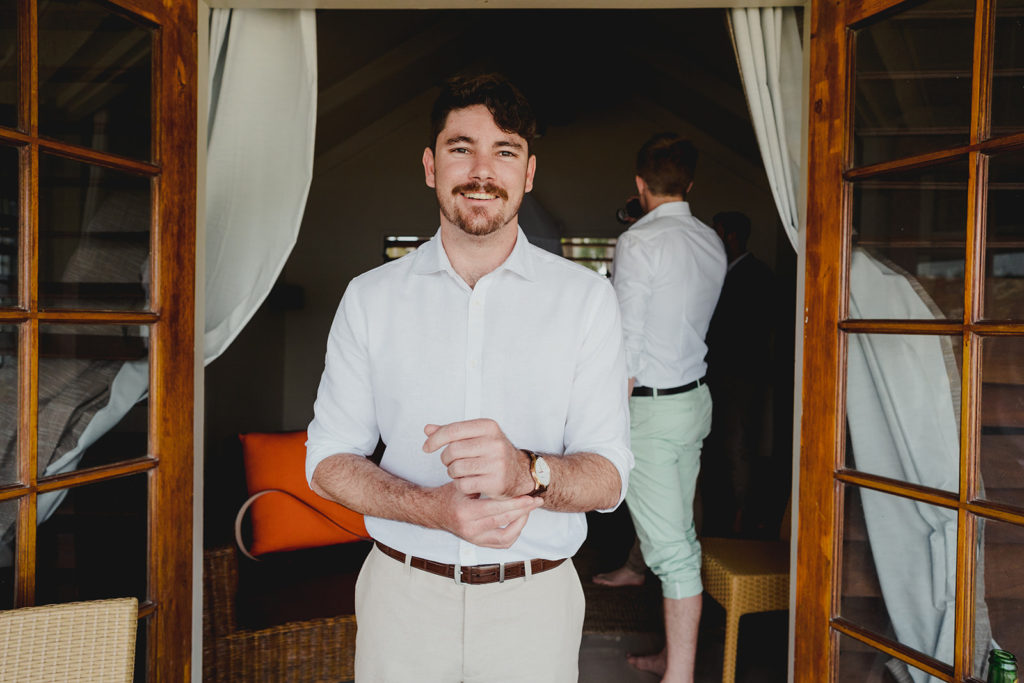 Groom getting ready in bungalow on Erakor Island